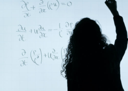 Frau notiert mit Stift Formel auf eine Tafel. weisse Tafel mit schwarzer Formel.
