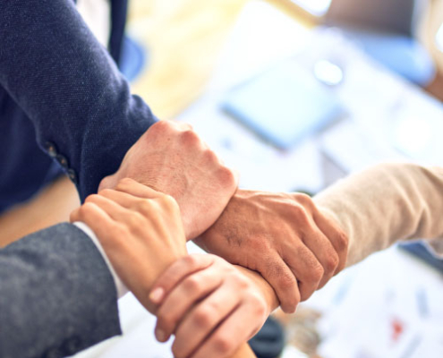 Hände die sich gegenseitig greifen im Büro. Teambild Hände halten sich gegenseitig.